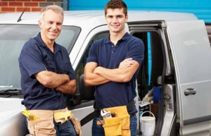 Owners of a Small Contracting Business Standing Next To a Van