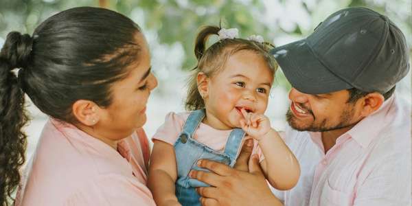 Padres sonrientes sosteniendo a su niño feliz. Padres sonrientes sosteniendo a su niño feliz.