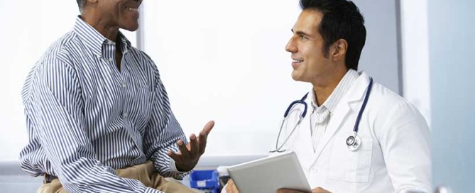 A male patient having a discussion with his male doctor in an exam room